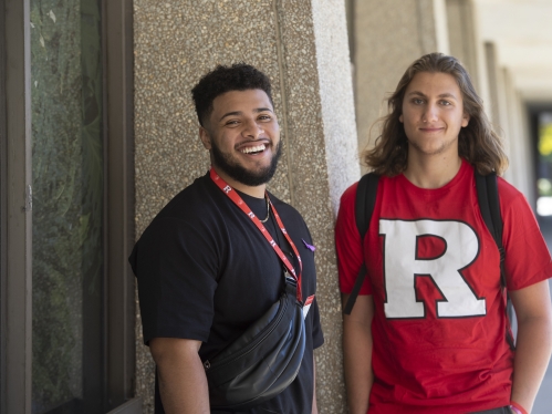 Two students stand outside a building on Livingston Campus